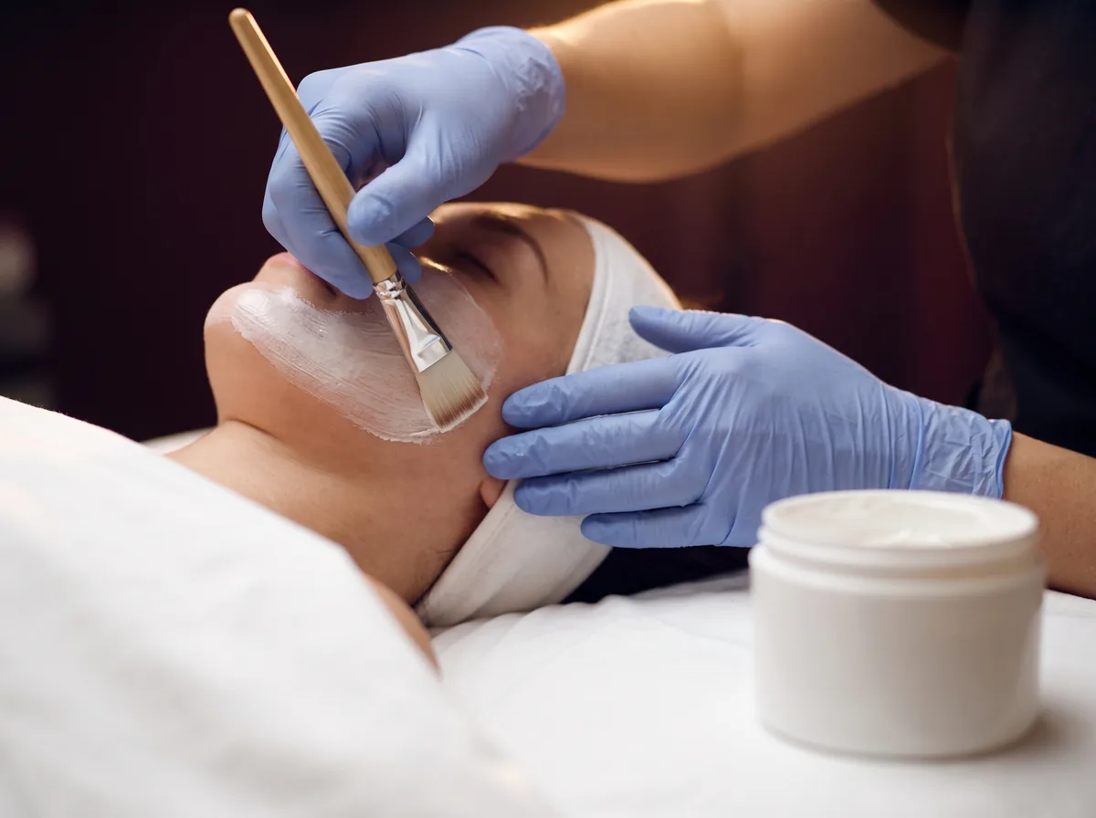 Aplicação de máscara facial com espátula profissional durante a preparação da pele