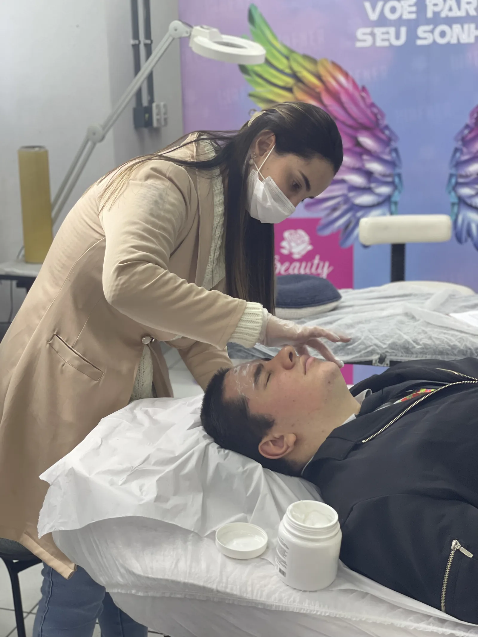 Professora aplicando produto no rosto durante a preparação da pele