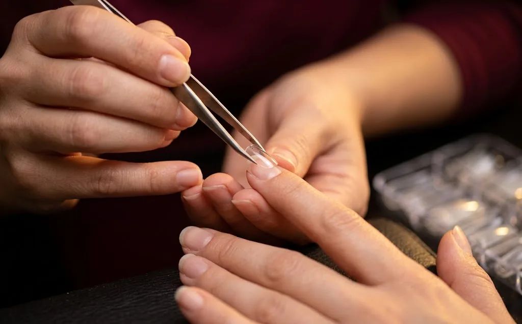 Aluna praticando aplicação de unhas postiças